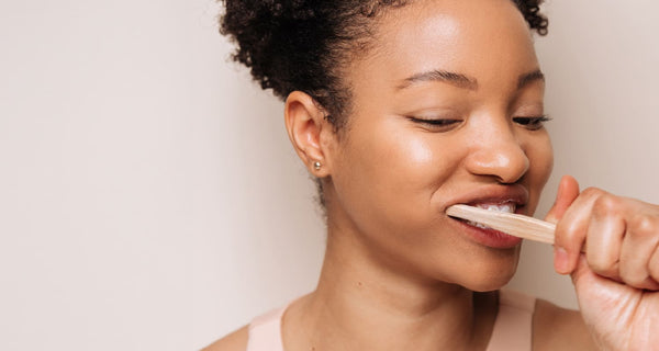 Woman brushing her teeth with fluoride free toothpaste | ATTITUDE